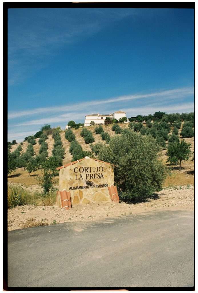 Eingangsschild Cortijo La Presa umgeben von Olivenhainen, Hochzeitslocation Andalusien, aufgenommen auf 35mm Film